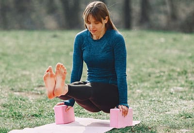 Frau übt mit zwei Yogablöcken