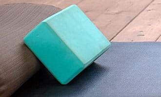 Yogablock aus festem Schaumstoff liegt auf einer Yogamatte