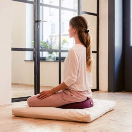 Frau sitzt in optimale Sitzposition für ihre Meditation