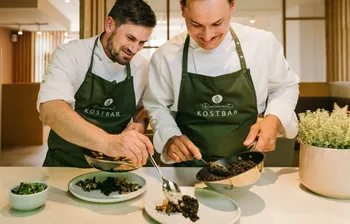 Zwei Köche bereiten gesundes Essen zu und richten es auf Tellern an