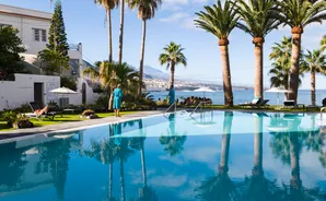 Infinity-Pool mit Atlantikblick unter Palmen